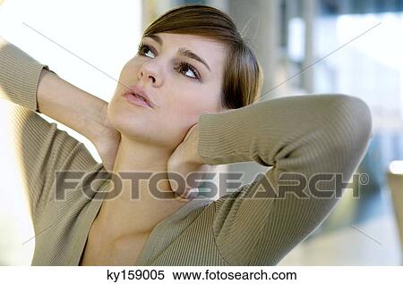 Close-up of a young woman with her hands on her neck View Large Photo Image Stock Photography - Close-up of a young woman with her hands on her neck. Fotosearch