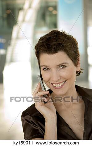 Mid adult woman talking on a mobile phone View Large Photo Image Stock Image - Mid adult woman talking on a mobile phone. Fotosearch