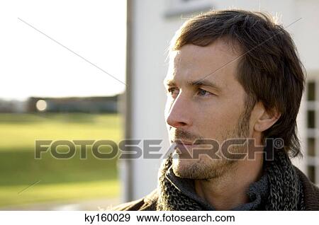 Close-up of a mid adult man looking away View Large Photo Image Stock Photo - Close-up of a mid adult man looking away. Fotosearch