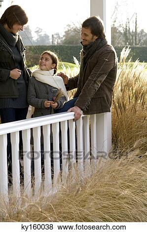 Girl standing and smiling with her parents View Large Photo Image Stock Photo - Girl standing and smiling with her parents. Fotosearch