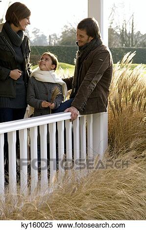 Girl standing and smiling with her parents View Large Photo Image Stock Photography - Girl standing and smiling with her parents. Fotosearch