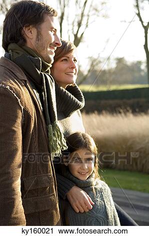 Girl standing with her parents View Large Photo Image Stock Image - Girl standing with her parents. Fotosearch
