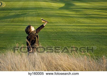 Side profile of a boy flying a paper airplane in a park View Large Photo Image Stock Photography - Side profile of a boy flying a paper airplane in a park. Fotosearch