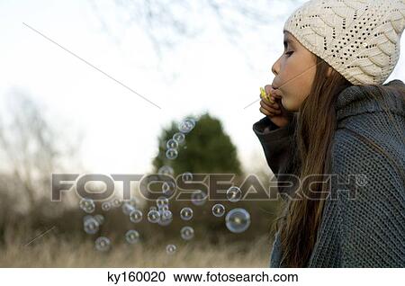 Side profile of a girl blowing bubbles with a bubble wand View Large Photo Image Stock Image - Side profile of a girl blowing bubbles with a bubble wand. Fotosearch