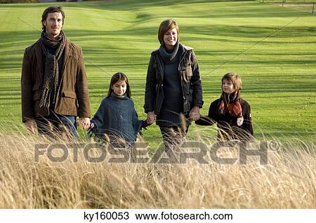 Two children with their parents walking in a park View Large Photo Image Stock Image - Two children with their parents walking in a park. Fotosearch
