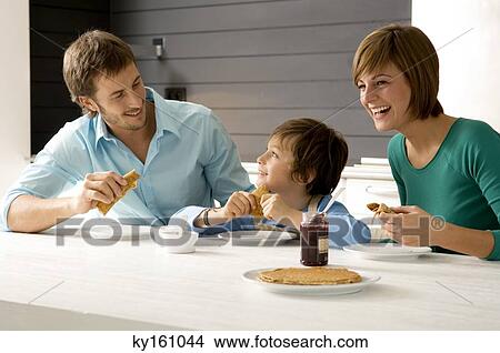 Picture - Mid adult man and a young woman having breakfast with their son. Fotosearch