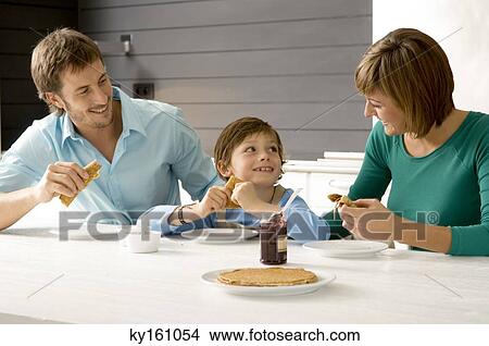 Mid adult man and a young woman having breakfast with their son View Large Photo Image Picture - Mid adult man and a young woman having breakfast with their son. Fotosearch