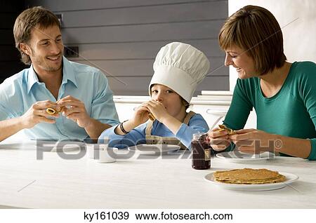 Mid adult man and a young woman having breakfast with their son View Large Photo Image Stock Photo - Mid adult man and a young woman having breakfast with their son. Fotosearch