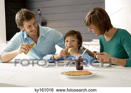 Mid adult man and a young woman having breakfast with their son View Large Photo Image Stock Photograph - Mid adult man and a young woman having breakfast with their son. Fotosearch