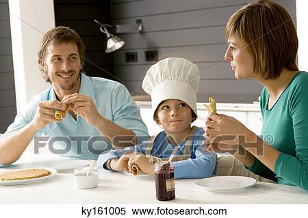 Stock Photography - Mid adult man and a young woman having breakfast with their son. Fotosearch