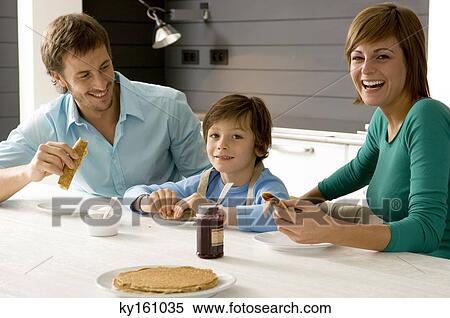 Mid adult man and a young woman having breakfast with their son View Large Photo Image Stock Photography - Mid adult man and a young woman having breakfast with their son. Fotosearch