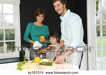 Mid adult man and a young woman preparing food with their son View Large Photo Image Picture - Mid adult man and a young woman preparing food with their son. Fotosearch
