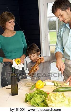 Mid adult man and a young woman preparing food with their son View Large Photo Image Stock Image - Mid adult man and a young woman preparing food with their son. Fotosearch