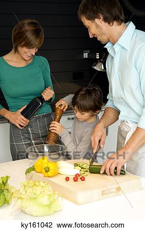 Mid adult man and a young woman preparing food with their son View Large Photo Image Stock Image - Mid adult man and a young woman preparing food with their son. Fotosearch