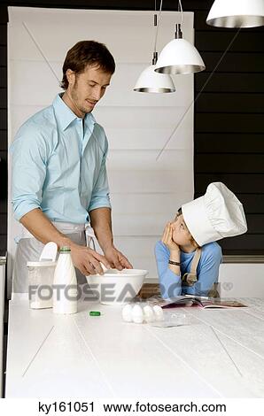 Mid adult man making a cake and his son in the kitchen View Large Photo Image Stock Image - Mid adult man making a cake and his son in the kitchen. Fotosearch