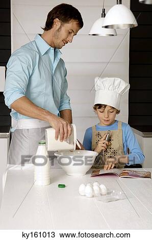 Mid adult man making a cake with his son in the kitchen View Large Photo Image Stock Image - Mid adult man making a cake with his son in the kitchen. Fotosearch