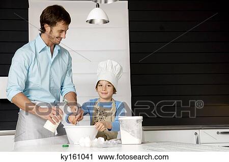 Mid adult man making a cake with his son in the kitchen View Large Photo Image Stock Image - Mid adult man making a cake with his son in the kitchen. Fotosearch