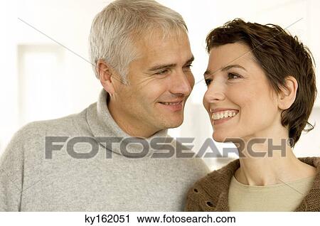 Stock Image - Close-up of a mature man and a mid adult woman smiling. Fotosearch