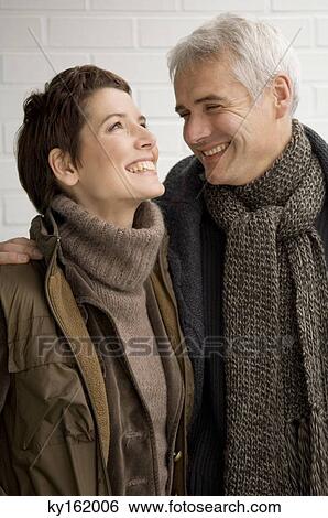 Stock Photograph - Close-up of a mature man and a mid adult woman standing. Fotosearch