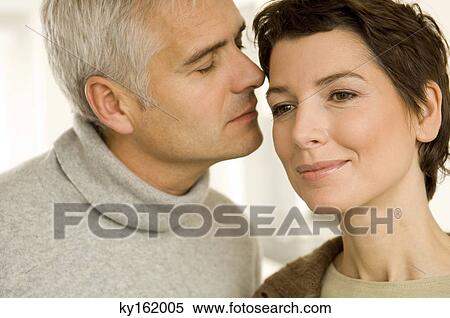 Stock Photography - Close-up of a mature man and a mid adult woman romancing. Fotosearch
