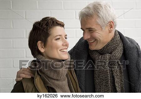 Close-up of a mature man arm around a mid adult woman and smiling View Large Photo Image Stock Photograph - Close-up of a mature man arm around a mid adult woman and smiling. Fotosearch