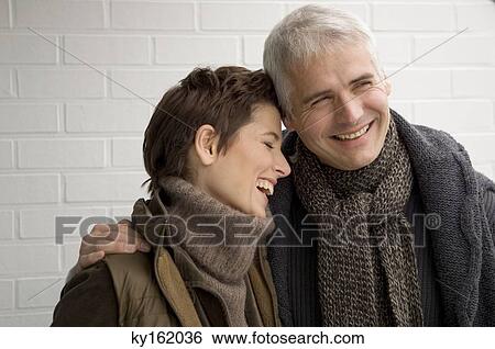 Close-up of a mature man arm around a mid adult woman and smiling View Large Photo Image Stock Photograph - Close-up of a mature man arm around a mid adult woman and smiling. Fotosearch