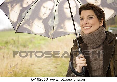 Close-up of a mid adult woman holding an umbrella View Large Photo Image Stock Image - Close-up of a mid adult woman holding an umbrella. Fotosearch