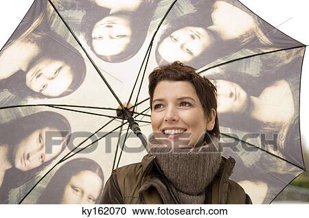 Close-up of a mid adult woman holding an umbrella View Large Photo Image Stock Image - Close-up of a mid adult woman holding an umbrella. Fotosearch
