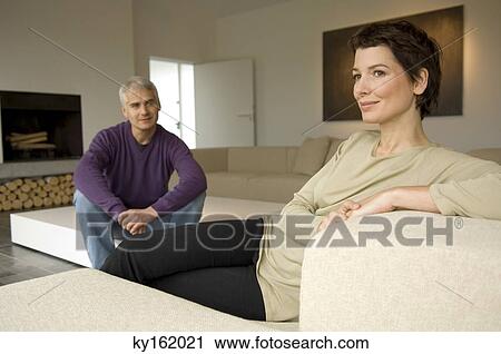 Mature man and a mid adult woman sitting in a living room View Large Photo Image Stock Image - Mature man and a mid adult woman sitting in a living room. Fotosearch