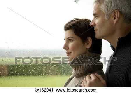 Mature man and a mid adult woman looking out through a window View Large Photo Image Stock Image - Mature man and a mid adult woman looking out through a window. Fotosearch