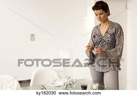 Mid adult woman lighting a candle with a cigarette lighter at a dining table View Large Photo Image Stock Image - Mid adult woman lighting a candle with a cigarette lighter at a dining table. Fotosearch