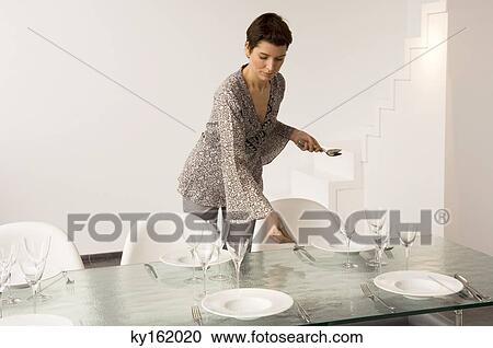 Mid adult woman setting a dining table View Large Photo Image Stock Image - Mid adult woman setting a dining table. Fotosearch