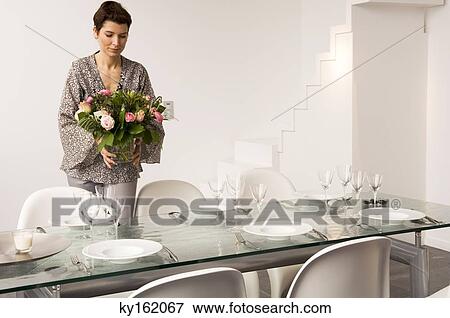 Mid adult woman setting a dining table View Large Photo Image Stock Photo - Mid adult woman setting a dining table. Fotosearch