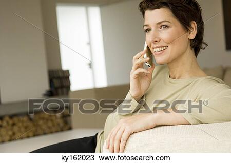 Mid adult woman talking on a mobile phone View Large Photo Image Stock Image - Mid adult woman talking on a mobile phone. Fotosearch