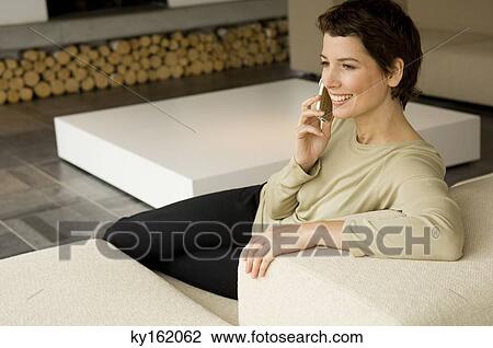 Mid adult woman talking on a mobile phone View Large Photo Image Stock Image - Mid adult woman talking on a mobile phone. Fotosearch