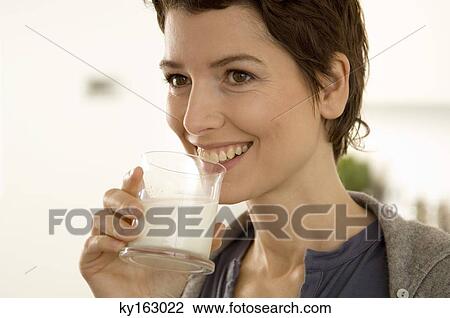 Close-up of a mid adult woman drinking a glass of milk View Large Photo Image Stock Image - Close-up of a mid adult woman drinking a glass of milk. Fotosearch