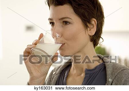 Close-up of a mid adult woman drinking a glass of milk View Large Photo Image Stock Image - Close-up of a mid adult woman drinking a glass of milk. Fotosearch