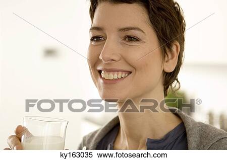 Stock Photography - Close-up of a mid adult woman holding a glass of milk. Fotosearch