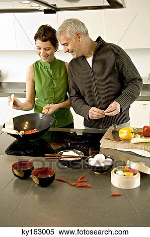 Mature man and a mid adult woman preparing food in the kitchen View Large Photo Image Stock Photography - Mature man and a mid adult woman preparing food in the kitchen. Fotosearch