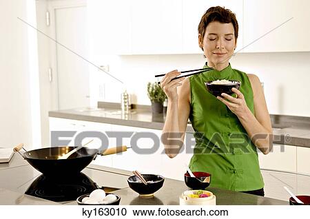 Mid adult woman smelling a bowl of rice in the kitchen View Large Photo Image Stock Image - Mid adult woman smelling a bowl of rice in the kitchen. Fotosearch