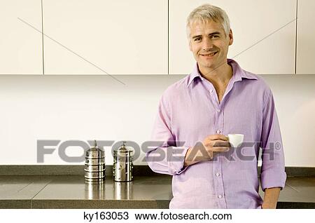 Portrait of a mature man holding a cup of tea and smiling View Large Photo Image Stock Image - Portrait of a mature man holding a cup of tea and smiling. Fotosearch