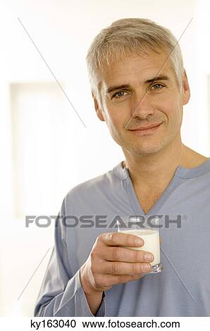 Portrait of a mature man holding a glass of milk View Large Photo Image Stock Image - Portrait of a mature man holding a glass of milk. Fotosearch