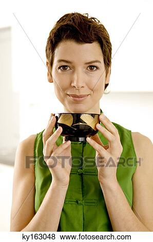 Portrait of a mid adult woman holding a bowl and smiling View Large Photo Image Stock Photo - Portrait of a mid adult woman holding a bowl and smiling. Fotosearch
