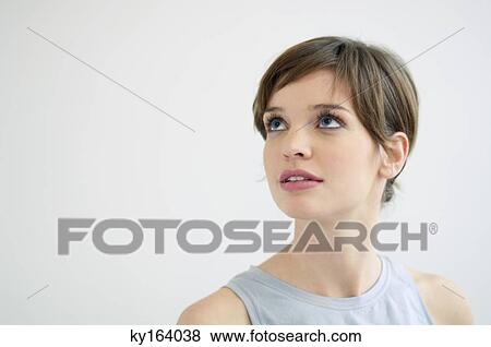 Stock Photo - Close-up of a young woman looking up and thinking. Fotosearch
