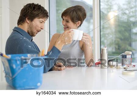 Couple holding cups of tea and smiling View Large Photo Image Picture - Couple holding cups of tea and smiling. Fotosearch