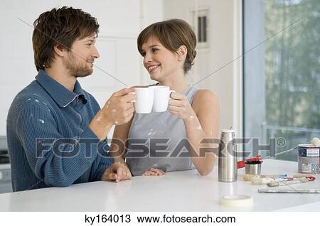 Couple holding cups of tea and smiling View Large Photo Image Stock Image - Couple holding cups of tea and smiling. Fotosearch