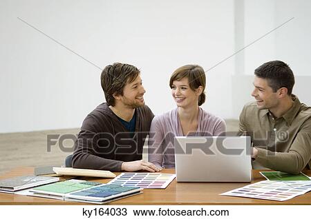Mid adult man and a young woman discussing with an interior designer View Large Photo Image Stock Image - Mid adult man and a young woman discussing with an interior designer. Fotosearch