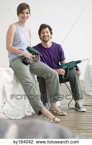 Portrait of a mid adult man and a young woman holding drills View Large Photo Image Stock Image - Portrait of a mid adult man and a young woman holding drills. Fotosearch
