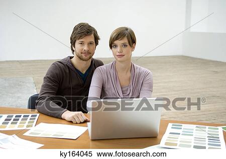Portrait of a mid adult man and a young woman using a laptop View Large Photo Image Stock Photography - Portrait of a mid adult man and a young woman using a laptop. Fotosearch