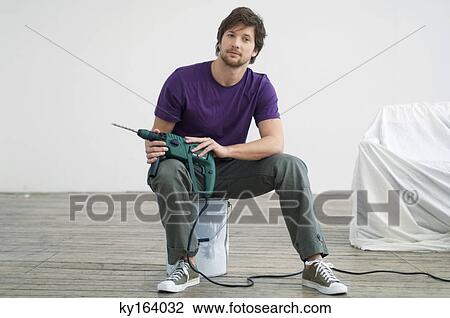 Portrait of a mid adult man holding a drill and sitting on a paint can View Large Photo Image Stock Image - Portrait of a mid adult man holding a drill and sitting on a paint can. Fotosearch
